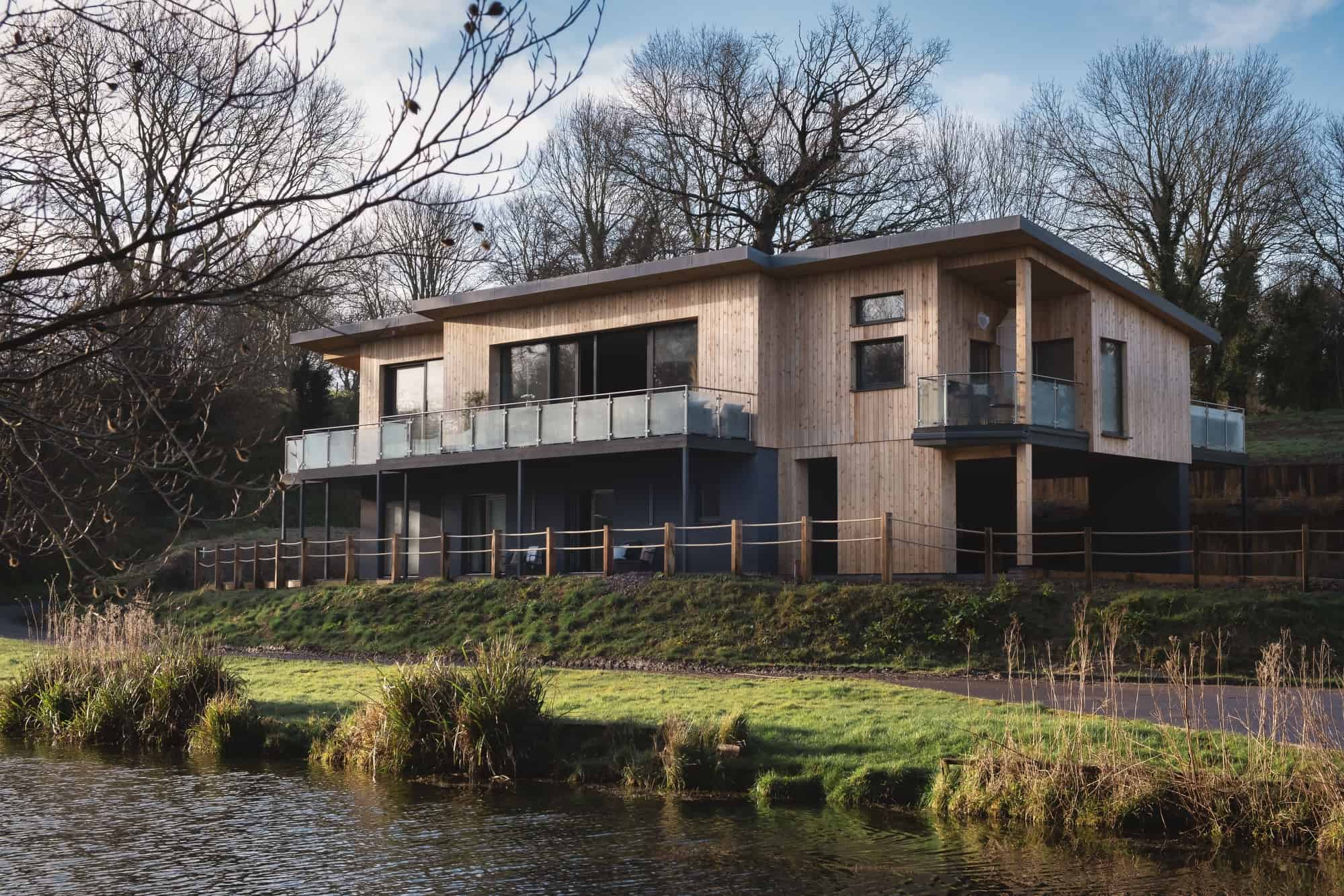 Calstone SN11 - A stunning lakeside lodge with four large bedrooms and wrap around terraces. Beautiful interiors with high end furnishings - The Location Guys